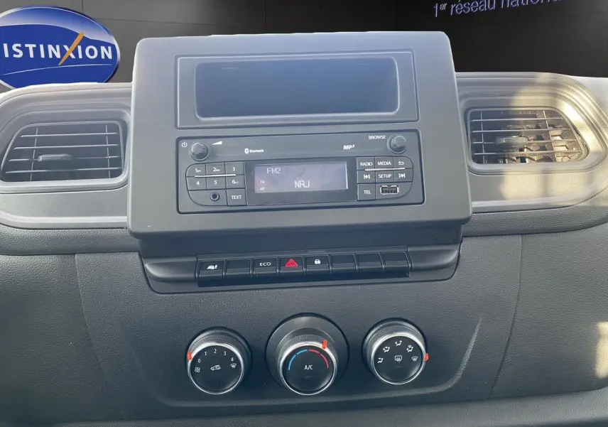 Vue rapprochée du tableau de bord noir du Renault Master 2024, avec commandes de climatisation et radio affichant NRJ.