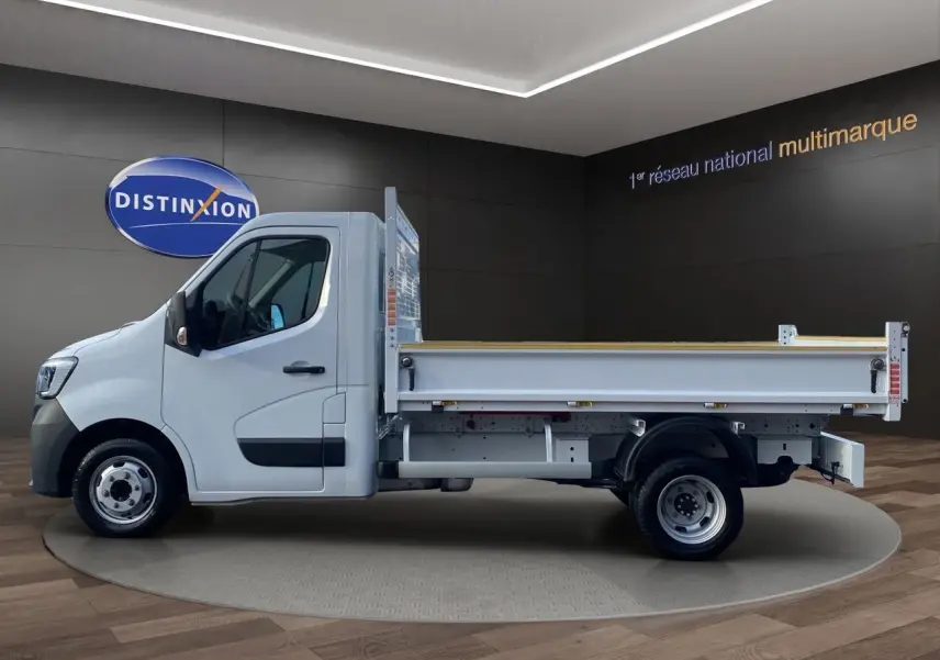 Renault Master blanc en vue profil côté gauche, benne arrière ouverte sur fond intérieur showroom.