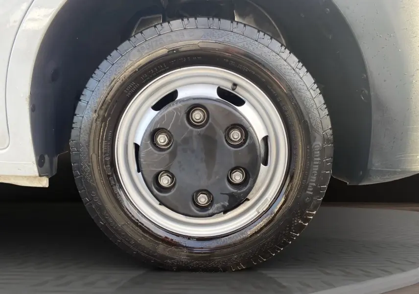 Gros plan sur la roue avant droite du Renault Master blanc 2024, avec jante acier et pneu Continental humide.