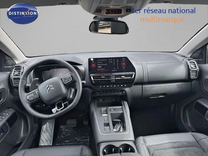 Vue intérieure avant du Citroën C5 Aircross gris Platinium, tableau de bord moderne avec écran tactile et volant multifonction cuir.