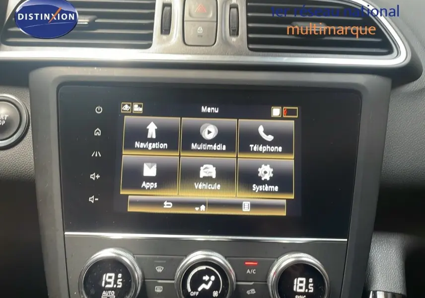 Vue rapprochée de la console centrale du Renault Kadjar bleu foncé, affichant l'écran tactile multimédia et les commandes de climatisation.