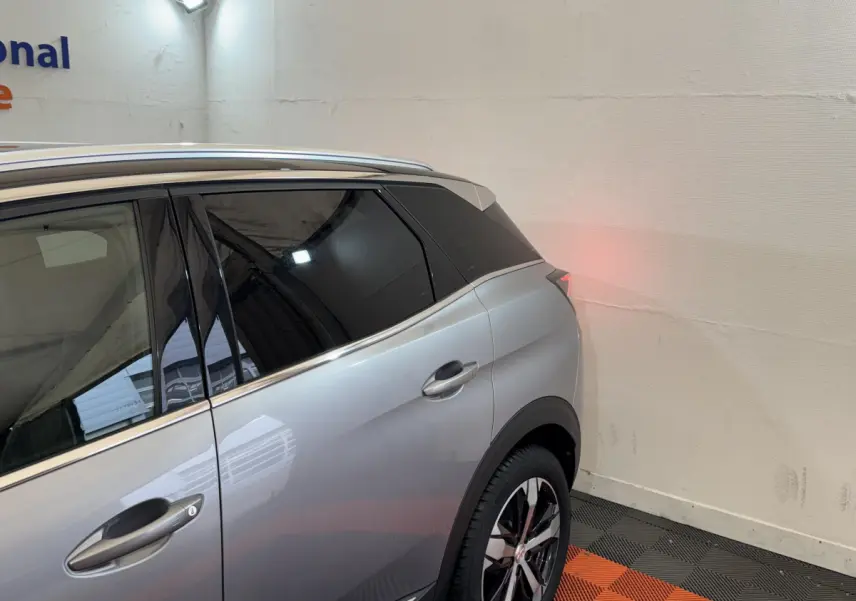 Vue latérale arrière droite d’un Peugeot 3008 gris clair avec vitres teintées et jantes alliage bicolores.