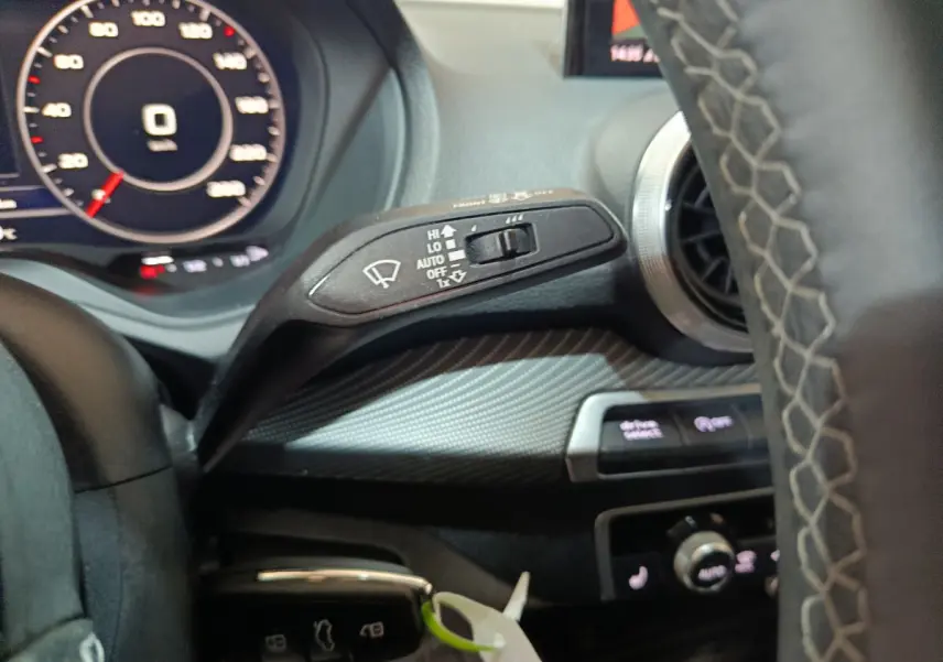 Gros plan sur le commodo d’essuie-glace côté gauche du tableau de bord noir de l’Audi Q2 35 TFSI 2022.