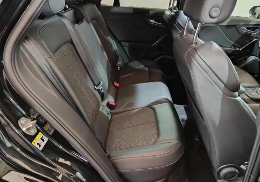 Vue côté gauche de l'habitacle arrière noir de l'Audi Q2 35 TFSI S Line Plus avec sièges cuir et tissu.