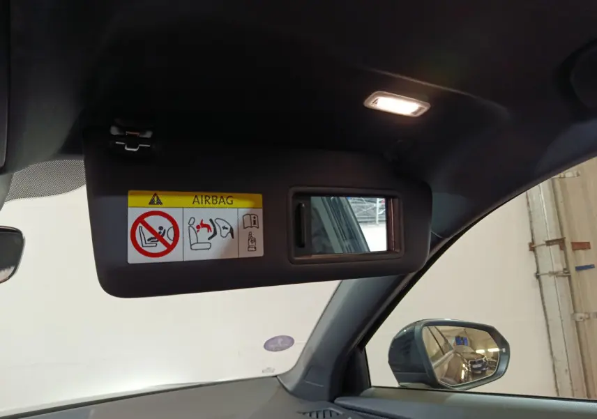 Miroir de courtoisie ouvert sur pare-soleil côté gauche dans l'habitacle noir d'un Audi Q2 35 TFSI S Line Plus 2022.