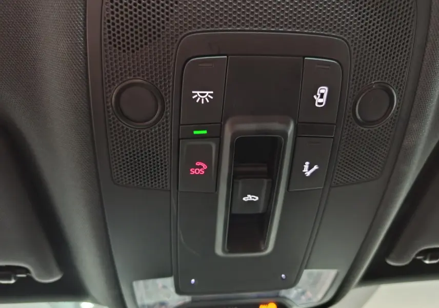 Vue en plongée sur la console de toit noire de l'Audi Q2 35 TFSI 2022 avec boutons SOS et ouverture coffre