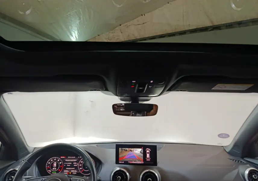 Vue intérieure avant de l'Audi Q2 noir 35 TFSI 2022 avec écran tactile et tableau de bord digital.