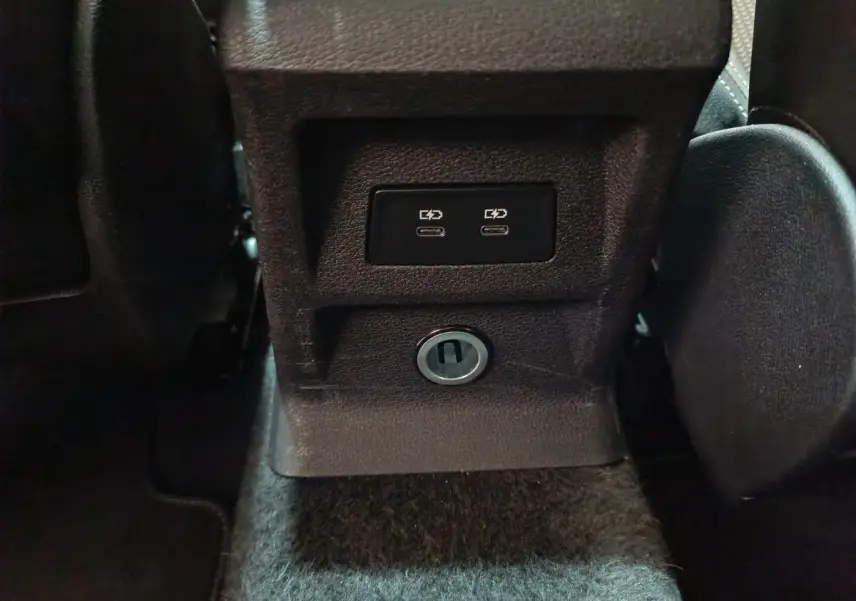 Prise USB double et prise 12V vue rapprochée sur la console centrale arrière d’un Audi Q2 noir 2022