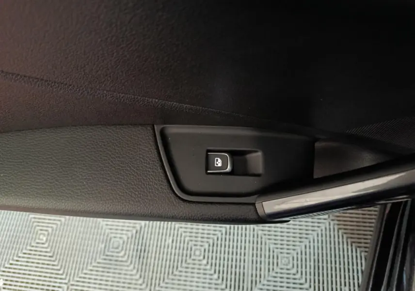 Bouton de verrouillage des portes sur la portière côté gauche d'un Audi Q2 noir 2022, finition S Line Plus.