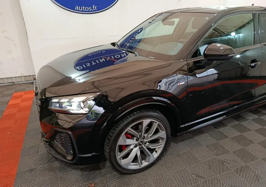 Audi Q2 35 TFSI S Line Plus noir vue 3/4 avant droit, avec jantes alliage et étriers de frein rouges visibles.