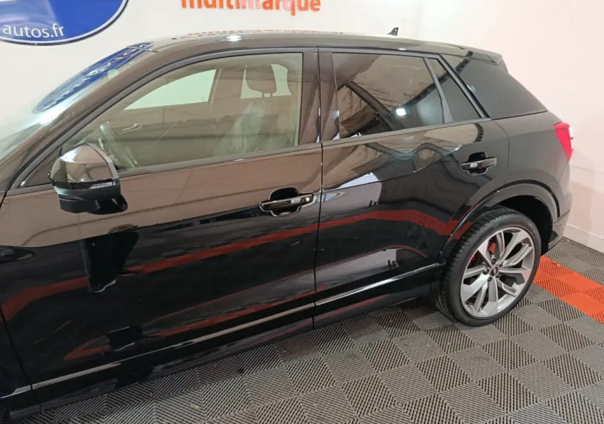 Profil côté gauche d'un Audi Q2 noir 35 TFSI S Line Plus avec jantes alliage et rétroviseur électrique.