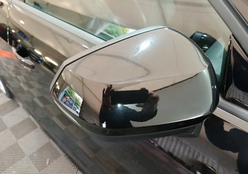 Rétroviseur droit noir brillant de l'Audi Q2 35 TFSI 150 S Line Plus 2022 avec carrosserie noire réfléchissante.