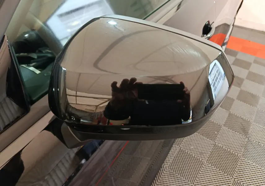 Rétroviseur extérieur noir brillant côté conducteur de l'Audi Q2 35 TFSI 2022 avec surface réfléchissante marquée.