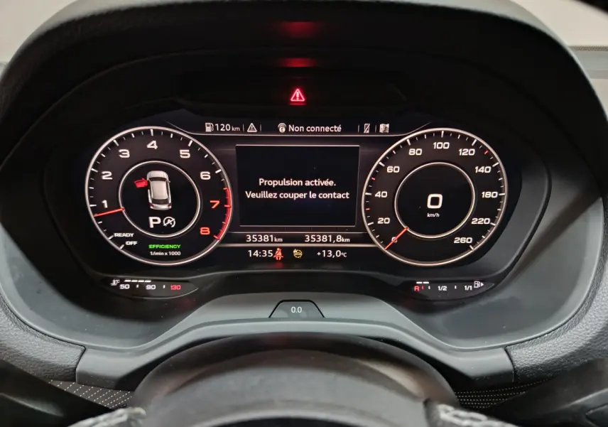 Vue rapprochée du tableau de bord numérique de l'Audi Q2 35 TFSI 150 S Line Plus avec affichage digital et message d'alerte.