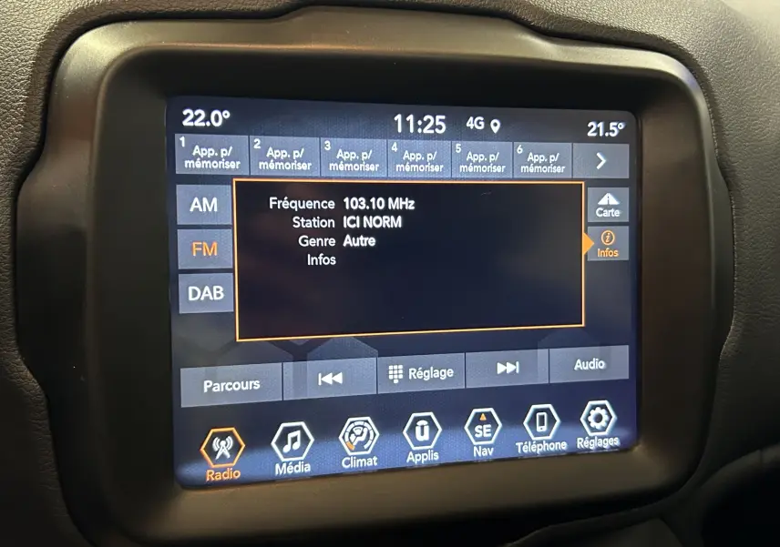 Écran tactile central du tableau de bord du Jeep Renegade 2023 affichant la radio FM et les options multimédia.