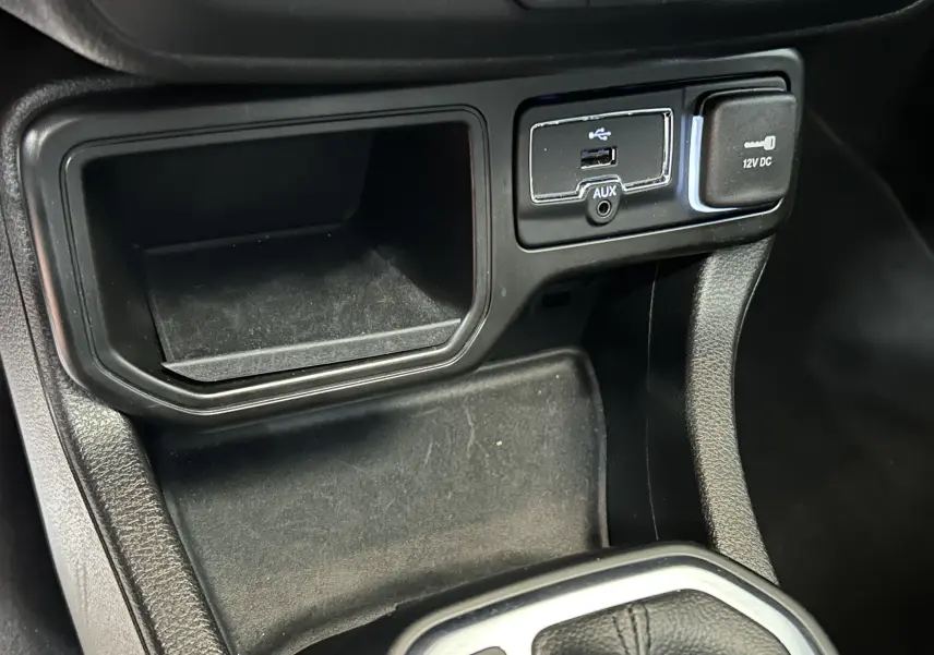 Détail de la console centrale noire avec prise USB, port AUX et prise 12V du Jeep Renegade 2023.