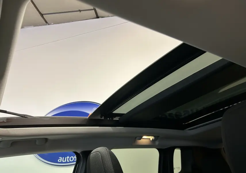 Vue intérieure du toit ouvrant panoramique ouvert sur Jeep Renegade gris graphite, mettant en valeur l'habitacle lumineux.