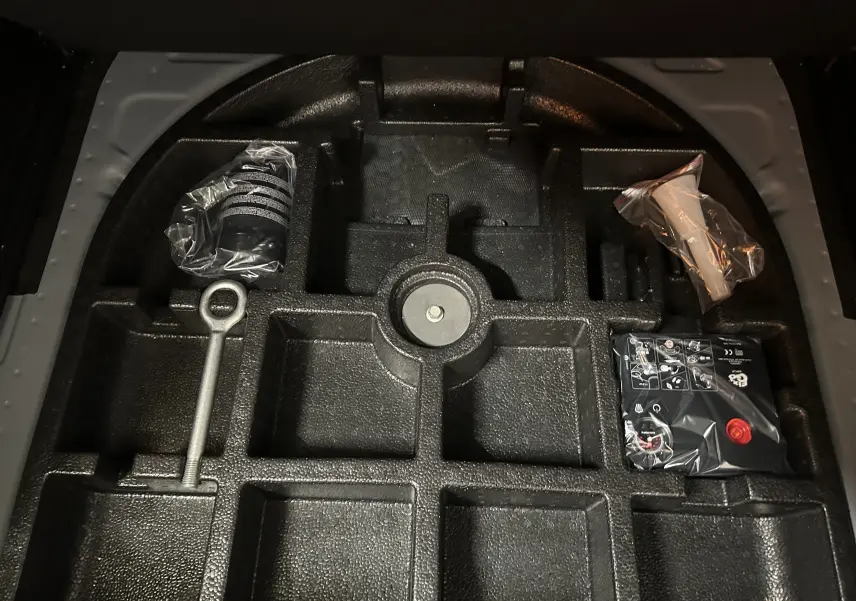 Coffre à outils et accessoires de secours dans le compartiment arrière d'un Jeep Renegade gris graphite, vue de dessus.