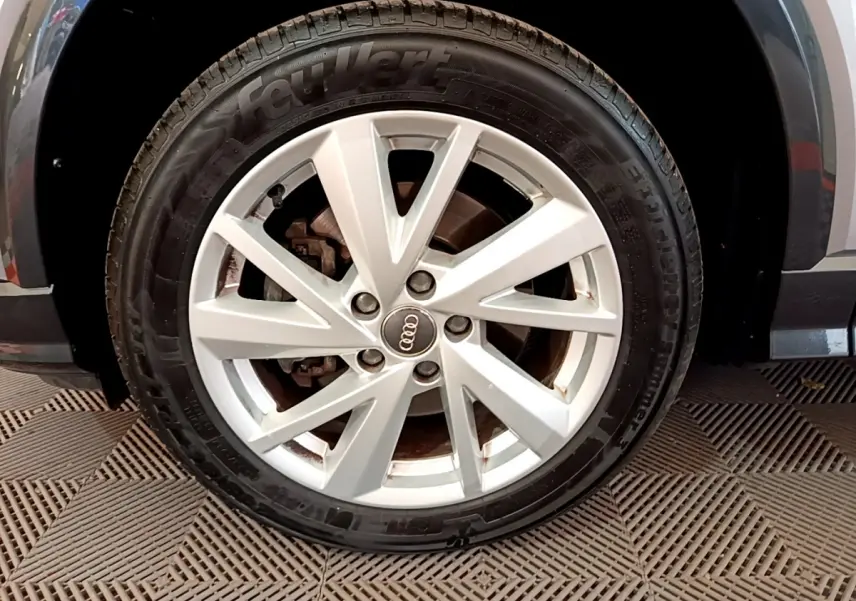 Gros plan sur la roue avant droite grise d’un Audi Q2 35 TDI 150 Design avec jante en alliage à 5 doubles branches.