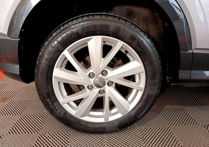 Gros plan sur la roue avant droite gris clair de l'Audi Q2 35 TDI 150 Design avec jante alliage à 5 doubles branches.