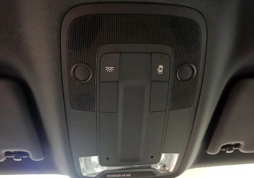 Vue en gros plan du plafonnier noir avec commandes d’éclairage et ouverture de toit de l’Audi Q2 gris clair 2020.