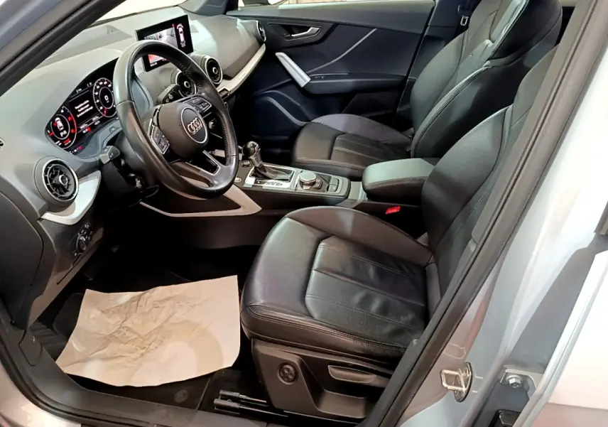 Intérieur noir de l'Audi Q2 35 TDI 150 Design 2020 vu côté conducteur, avec tableau de bord digital et volant cuir.