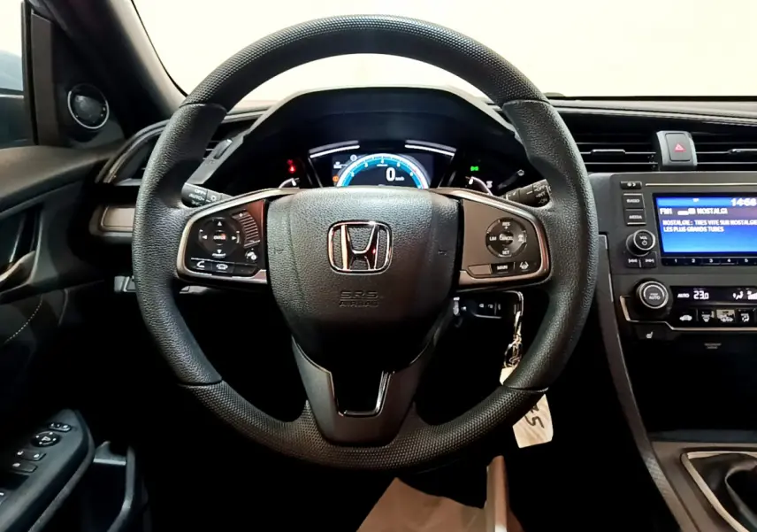 Intérieur de la Honda Civic 1.0 i-VTEC Exclusive 2020, vue frontale du volant cuir et tableau de bord digital.