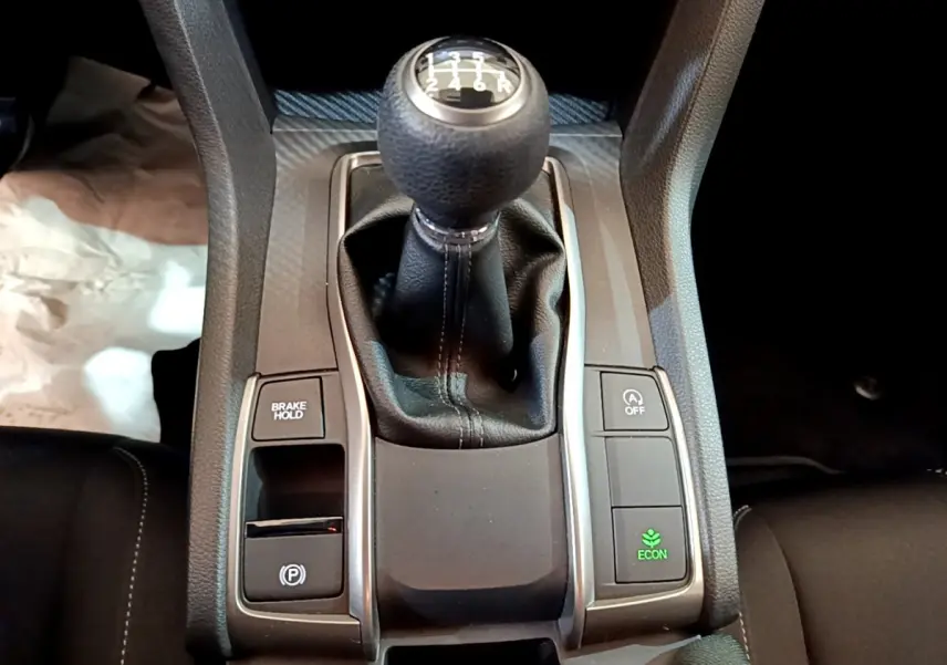 Gros plan sur le levier de vitesse manuel de la Honda Civic 1.0 i-VTEC Exclusive 2020 avec boutons de contrôle autour.
