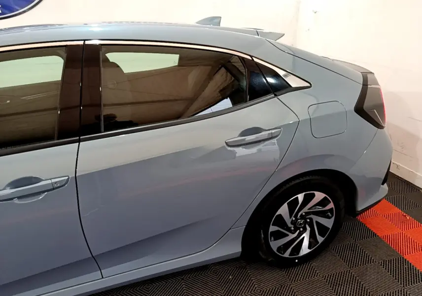 Vue latérale droite de la Honda Civic 1.0 i-VTEC Exclusive gris foncé, mettant en valeur les jantes alliage et la ligne de toit dynamique.