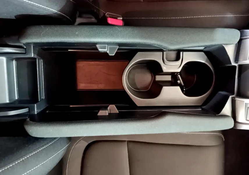 Vue plongeante sur la console centrale noire avec porte-gobelets et accoudoirs en tissu de la Honda Civic gris foncé 2020.