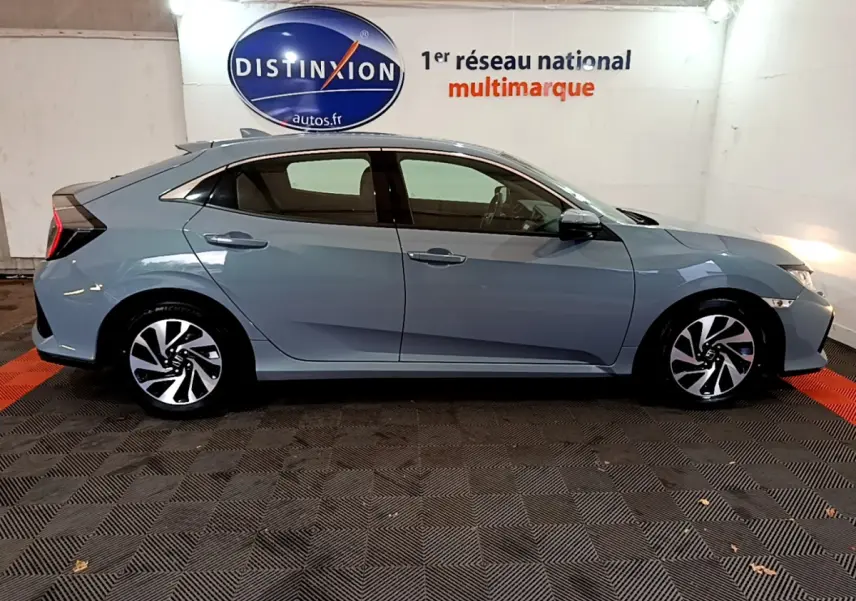 Profil côté gauche d'une Honda Civic 1.0 i-VTEC Exclusive gris foncé, avec jantes alliage et feux arrière distinctifs.