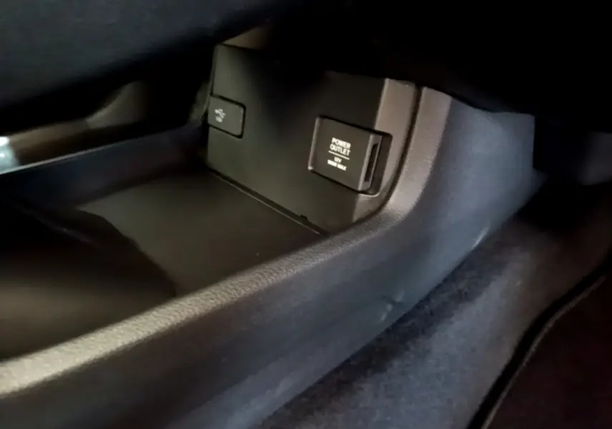 Prise 12V et port USB dans le compartiment central de la Honda Civic 1.0 i-VTEC Exclusive gris foncé, vue intérieure côté passager.