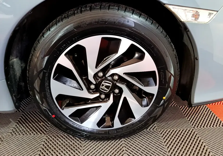 Gros plan sur la roue avant gauche de la Honda Civic 1.0 i-VTEC Exclusive gris foncé avec jante alliage moderne.