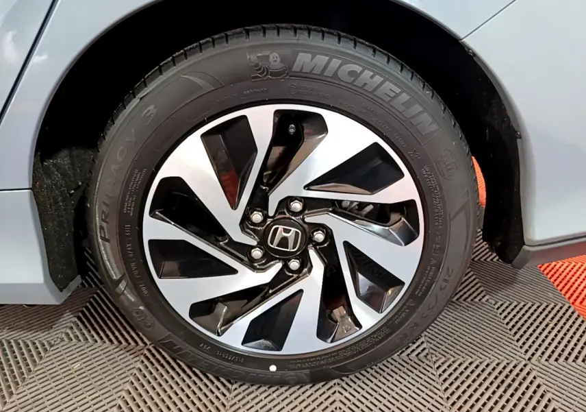 Gros plan sur la roue avant droite grise d'une Honda Civic 1.0 i-VTEC Exclusive avec jante alliage distinctive.