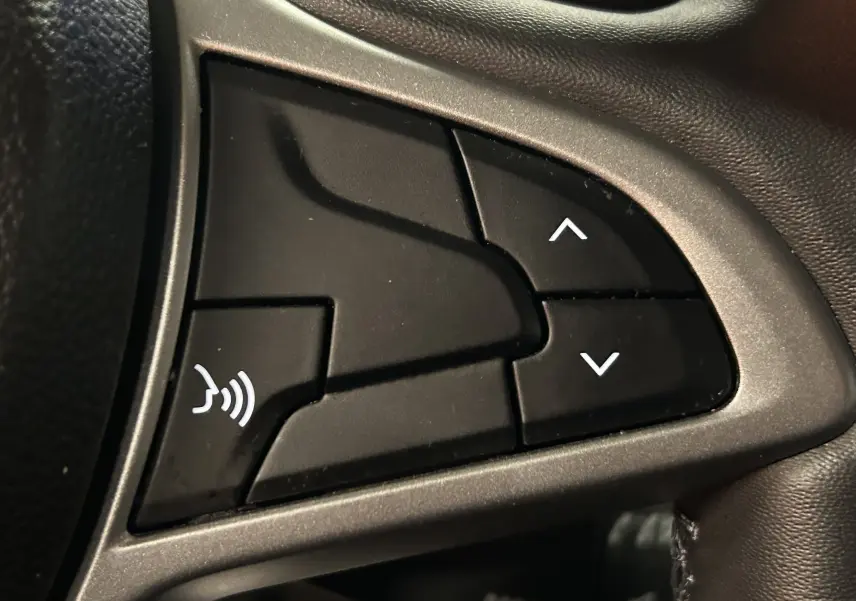 Gros plan sur les boutons de commande au volant du Dacia Duster 2024, finition Expression, intérieur noir.