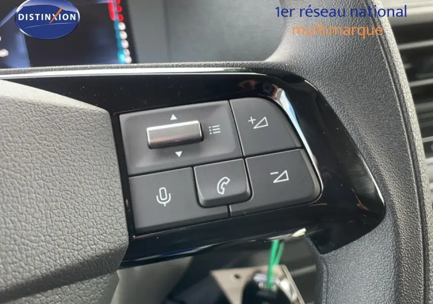 Gros plan sur les commandes au volant côté gauche du Citroën Jumpy gris titane, boutons de volume et téléphone visibles.