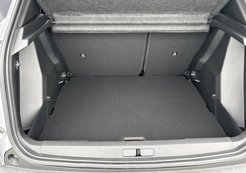 Coffre ouvert vu de l'arrière d'une Peugeot 2008 gris Artense avec intérieur noir et banquette rabattable.