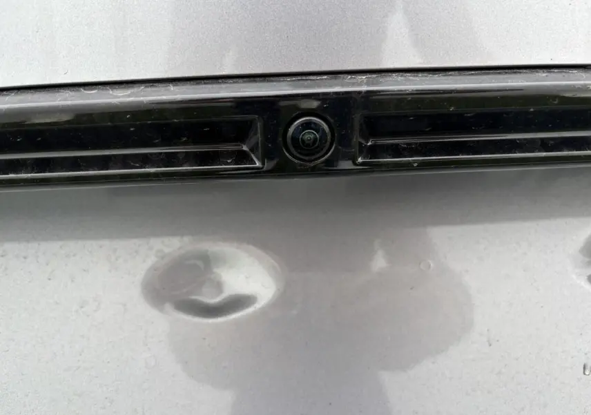 Gros plan sur la caméra 360° arrière intégrée à la plaque d’immatriculation du Peugeot 2008 gris Artense.