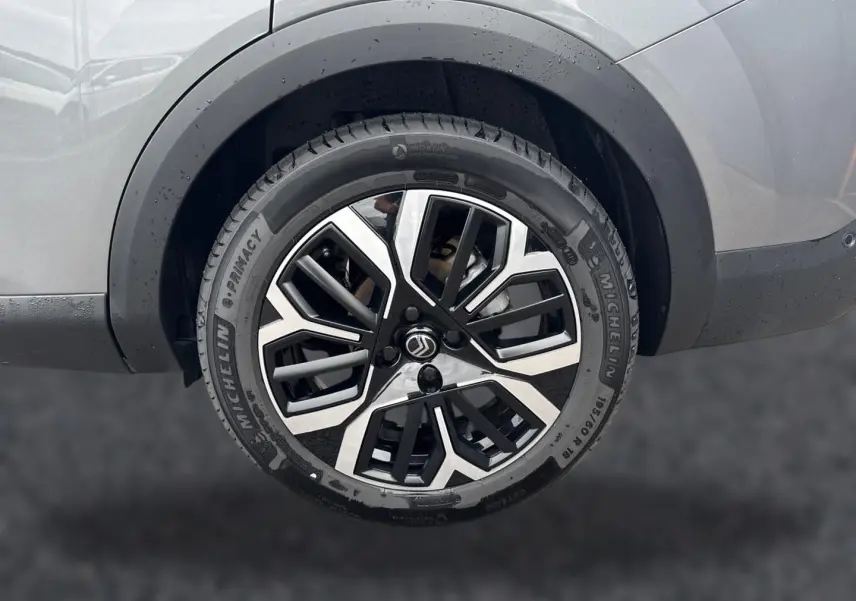 Gros plan sur la roue arrière droite gris mercure d'une Citroën C4 X 2025 avec jante alu bicolore et pneus Michelin.