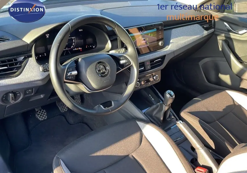 Intérieur avant du Skoda Kamiq 2024 noir magique métal, volant multifonction et levier de vitesse manuel visible de côté gauche.