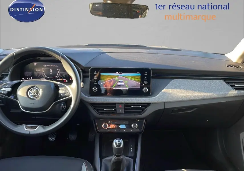 Intérieur du Skoda Kamiq 2024 noir magique métal, vue frontale sur le tableau de bord et la console centrale avec boîte manuelle.