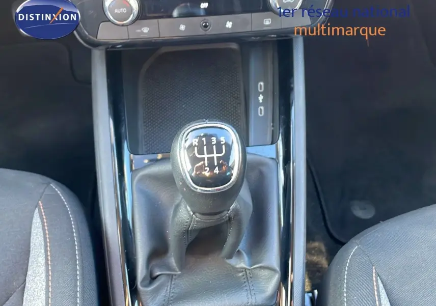 Le levier de vitesses manuel noir du Skoda Kamiq 2024, vu de dessus entre les sièges gris foncé.