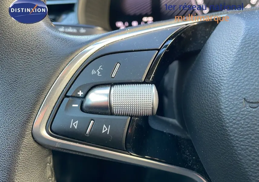 Gros plan sur les commandes audio au volant du Skoda Kamiq 2024 noir magique métal, côté gauche du volant.