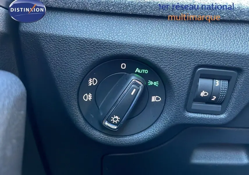 Gros plan sur le sélecteur de phares noir et la molette de réglage d'intensité lumineuse dans une Skoda Kamiq noire.