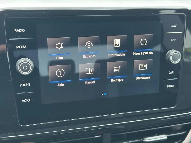 Écran tactile central du Volkswagen T-Roc 2025 gris, affichant le menu des réglages et options multimédia.