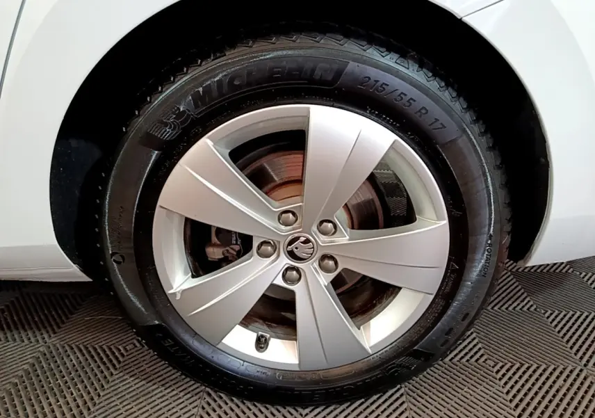 Gros plan sur la roue avant droite de la Skoda Superb blanche, avec jante alliage et pneu Michelin visible.