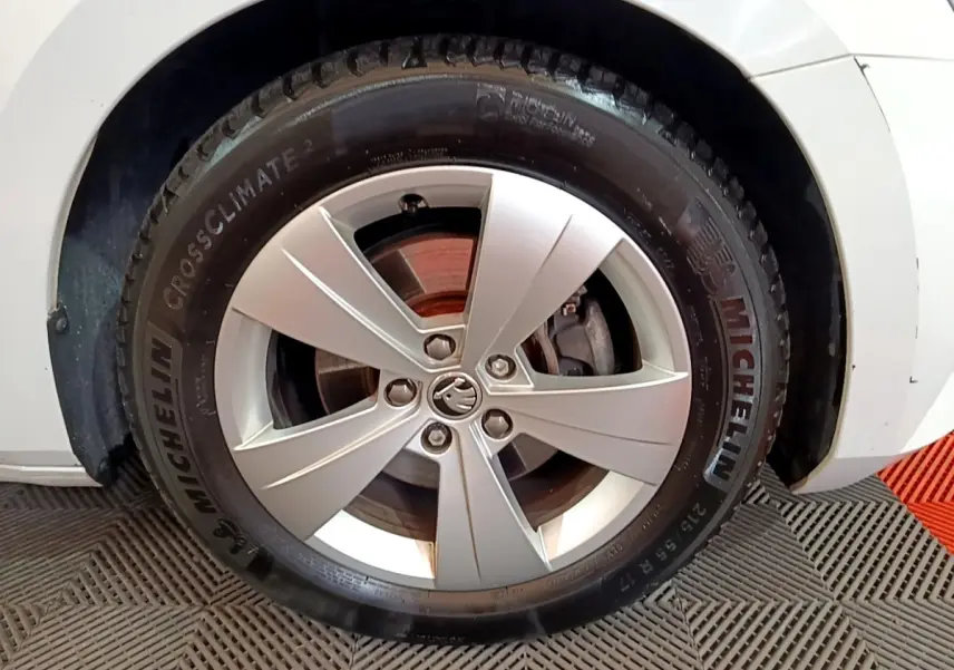 Gros plan sur la roue avant droite d'une Skoda Superb blanche, jante alliage et pneu Michelin CrossClimate 2.