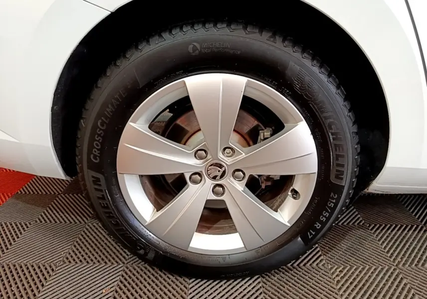 Gros plan sur la roue avant gauche d’une Skoda Superb blanche avec jante alliage cinq branches et pneu Michelin.