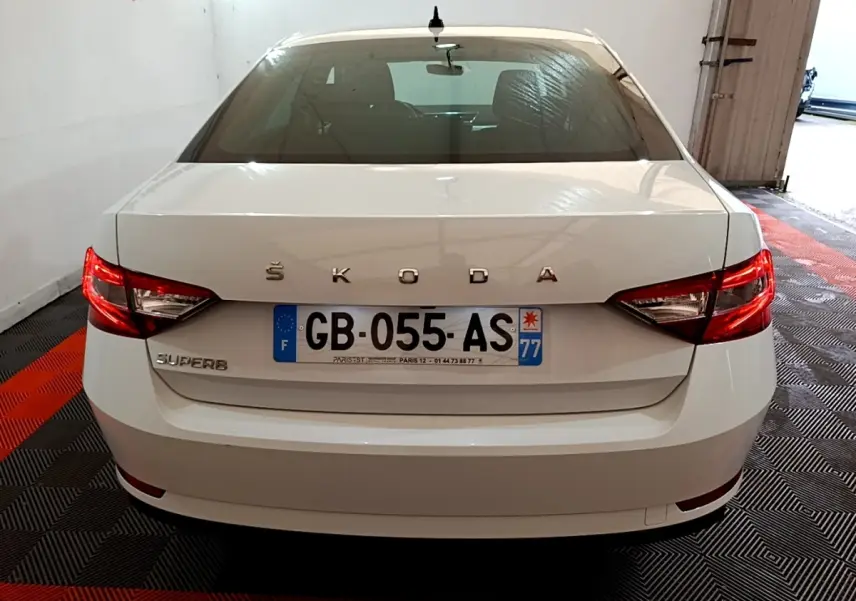 Vue arrière d'une Skoda Superb blanche 2021 avec feux LED et plaque d'immatriculation française visible.