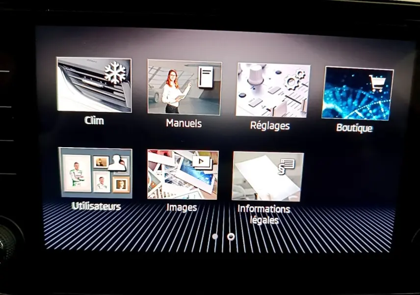 Écran tactile intérieur de la Skoda Superb blanc, affichant le menu principal avec icônes colorées.